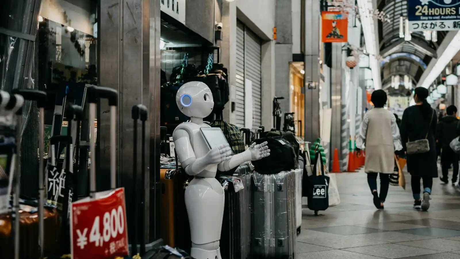 robot with tablet in front of store at the mall by Lukas on Unsplash